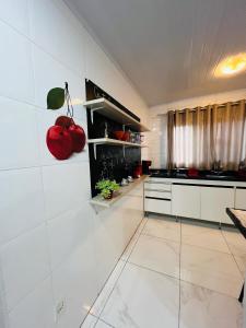 索罗卡巴Casa do Henrique 2的墙上有红色苹果的白色厨房