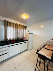 索罗卡巴Casa do Henrique 2的带冰箱和桌子的厨房