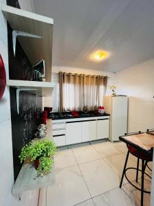 索罗卡巴Casa do Henrique 2的厨房配有白色橱柜和炉灶烤箱。