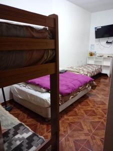 利马Hospedaje Del Pilar en Magdalena del Mar的一间卧室配有两张双层床和电视