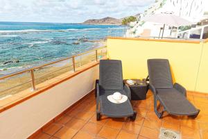 大加那利岛拉斯帕尔马斯梅普康缇瑞斯公寓酒店的俯瞰大海的阳台配有两把椅子和一张桌子
