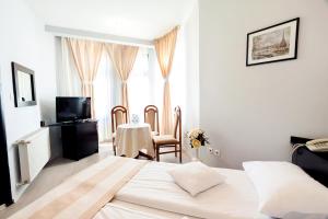 格奥尔盖尼阿斯托利亚酒店及餐厅的卧室配有一张床和一张桌子及椅子