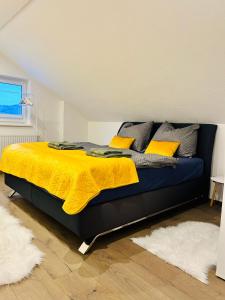 格蒙登Idyllische Suite in Zentrumsnähe mit Parkplatz Top 1的一间卧室配有一张黄色毯子床