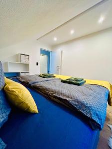 格蒙登Idyllische Suite in Zentrumsnähe mit Parkplatz Top 1的一间卧室配有一张带黄色和蓝色床单的大床