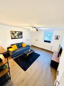 格蒙登Idyllische Suite in Zentrumsnähe mit Parkplatz Top 1的客厅配有蓝色的沙发和黄色的枕头。