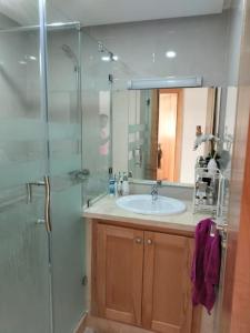 Oulad YakoubCosy appartement à proximité de l'aéroport de salé et technopolis的一间带水槽和玻璃淋浴的浴室