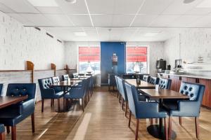 奥斯卡港索法特贝斯特韦斯特酒店的用餐室配有木桌和蓝色椅子