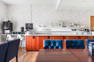 奥斯卡港索法特贝斯特韦斯特酒店的厨房配有桌子和蓝色的椅子