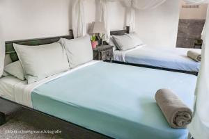 圣何塞Lost in San Jose Hostel & Suites的一间带两张床和一张沙发的卧室