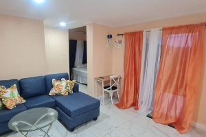 昂斯拉雷区The Den & Deck的客厅配有蓝色的沙发和橙色窗帘