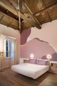 卡利亚里Casa Clat的卧室配有一张白色大床和紫色墙壁