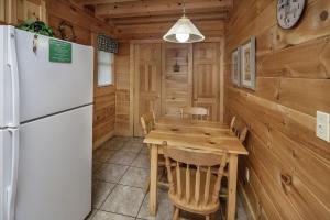鸽子谷ER206 - Mountain Rendezvous Great location - Close to town! cabin的厨房以及带冰箱和桌子的用餐室。