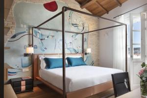 卡利亚里Casa Clat的一间卧室配有一张带蓝色枕头的天蓬床