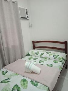 曼达维市Cozy9-14 2BR at Mandaue City的一张带绿床罩的床,上面有卷