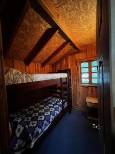 内尔图梅Cabañas Llakolen的小屋内带两张双层床的客房