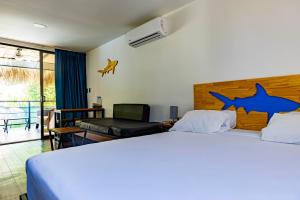 圣塔特蕾莎海滩Shark Town Mal Pais的卧室配有一张大床,墙上挂着鲨鱼标记