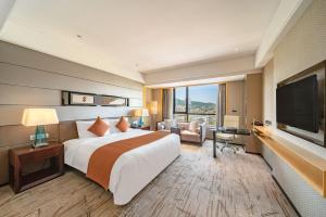 广州广州日航酒店 - 免费单程从酒店送至奥体&宝能演唱会的一间酒店客房,配有一张大床和一台平面电视