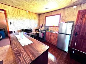 延基韦Lugar de descanso, con Tinaja al aire libre.的厨房配有不锈钢冰箱和木地板
