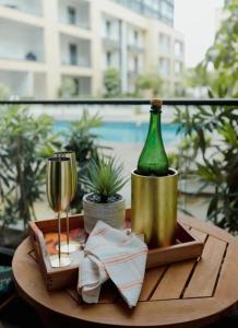 阿克拉Enjoy Luxury Studio w/Pool @Embassy Gardens的一张木桌,上面放着一瓶葡萄酒和一杯