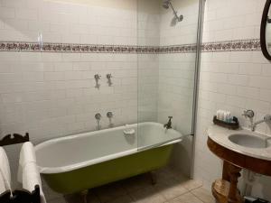 戴尔斯福特Albert Hotel Daylesford的浴室配有绿色浴缸和水槽