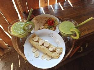 特特巴图Girang Rinjani Bungalows的一张桌子,上面放着一盘食物和两杯饮料