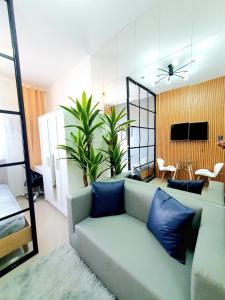 达斯马里尼亚斯Green 2 Residences Scandi-Industrial Hotel Type Interior的客厅配有带蓝色枕头的沙发