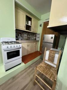 格罗斯岛Homely Environment Studio Apt的厨房配有炉灶和椅子