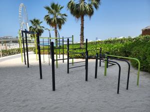 迪拜The Star @ Address Beach Residence的棕榈树环绕的沙滩上的游乐场