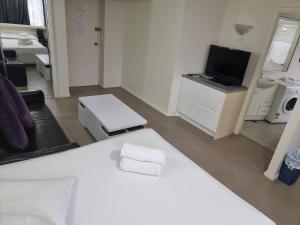 悉尼Accommodation Sydney - Hyde Park Plaza 38 College St Sydney的卧室配有白色的床和电视。