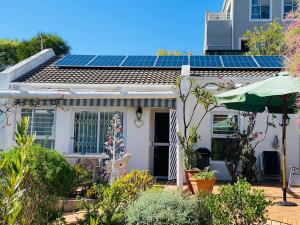 豪特湾Sunbird的屋顶上设有太阳能电池板的白色房子