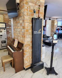 春川Hotel Gongjicheon的壁炉旁的砖墙,带钢琴