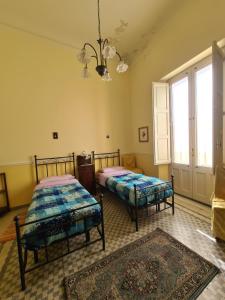 米罗Residenza Maria Letizia的一间卧室配有两张床和吊灯。