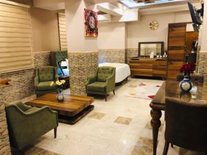 纳杰夫Royal Eagle Hotel的酒店客房带一张床、一张桌子和椅子