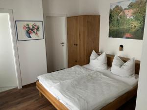 瓦勒湖畔诺伊马克特Gasthaus Eggerberg的一间卧室配有带白色床单和枕头的床。