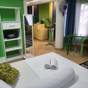 长滩岛长滩岛绿猴度假酒店的一间绿色墙壁和一张带毛巾的床的房间