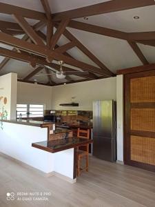 TevaitoaLa Maison Du Voyage的大型厨房设有木制天花板和冰箱。