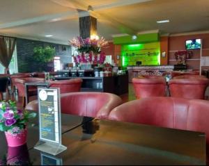 索龙THE IGNISLO HOTEL SORONG的一间设有红色皮革椅子的餐厅和一间酒吧
