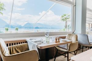 梅尔里根贝尔多斯康体SPA酒店的餐厅设有桌椅和大窗户。