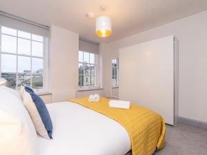巴斯Pass the Keys Stunning 2 bed retreat in the heart of Bath的卧室配有一张白色大床和黄色毯子