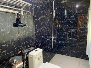 昆岛Kim's Garden的黑色和金色的浴室设有卫生间和淋浴。