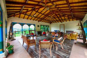 加尔加Paatlidun Safari Lodge, Jim Corbett的大型客厅设有木制天花板和家具。