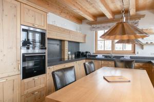 皮森多夫AvenidA Panorama Chalet by Alpin Rentals的厨房配有木桌、椅子和安乐灯