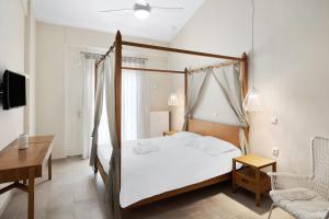 RachesAria Monte Villas的一间卧室配有一张天蓬床、一张桌子和一把椅子