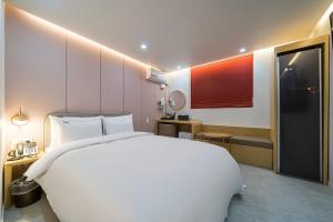 春川Browndot Hotel Namchuncheon的一间带白色大床的卧室和一间浴室