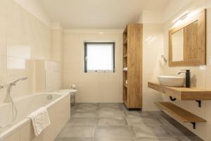 因泽尔Inzell Chalets by ALPS RESORTS的白色的浴室设有浴缸和水槽。