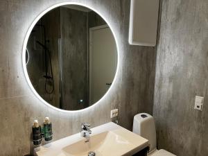 史特林Stryn House - Hotel & Apartments的一间带水槽和镜子的浴室