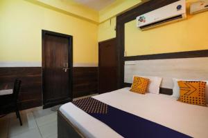 坎普尔Hotel Aditya Palace By WB Inn的一间卧室配有带橙色和蓝色枕头的床