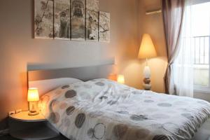 圣但尼Bright well-appointed nest near Stade de France的一间卧室配有一张床、两盏灯和一个窗户。