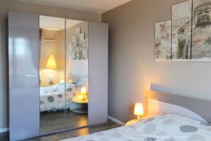 圣但尼Bright well-appointed nest near Stade de France的一间卧室配有一张床和一个带镜子的橱柜