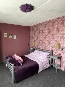 巴伦德雷赫特Bed and breakfast devijfbees的一间卧室配有一张床和紫色的墙壁